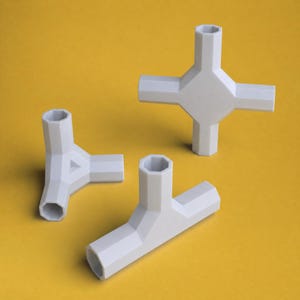 May include: Three white plastic structural connectors with hexagonal cross-sections. One piece features a four-way cross configuration, one is a three-way corner joint, and the third is a T-shaped connector with open ends for assembly.