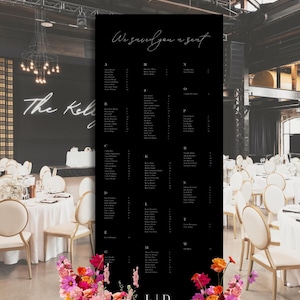 Peut inclure: Un plan de table noir avec du texte blanc indiquant « We saved you a seat ». La liste des noms est classée par ordre alphabétique. Les initiales « L | D » figurent en bas. Des compositions florales colorées roses, oranges et jaunes ornent la base.