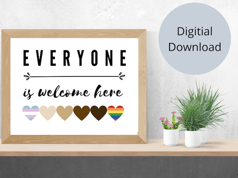 May include: A framed print with the text "EVERYONE is welcome here" in black. Below the text are six hearts in various colors, including a rainbow and transgender flag. The words "Digital Download" are in a light blue circle.
