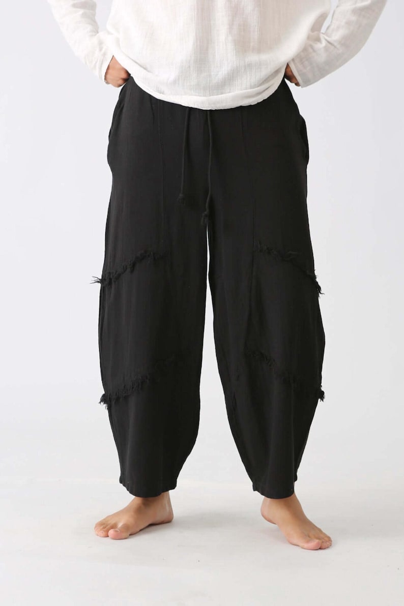 Handmade black linen palazzo pants with drawstring waist, boho harem style, distressed patches; barefoot model in white top.