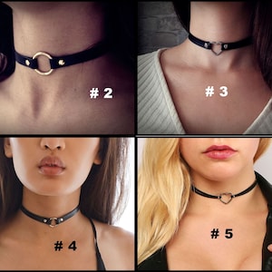 May include: Four different styles of black leather choker necklaces with silver accents. The chokers feature a circle, heart, and two different heart shapes.