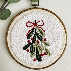 Finished Mistletoe Punch Needle Décor for Christmas Holiday. Shown in faux wood display hoop.