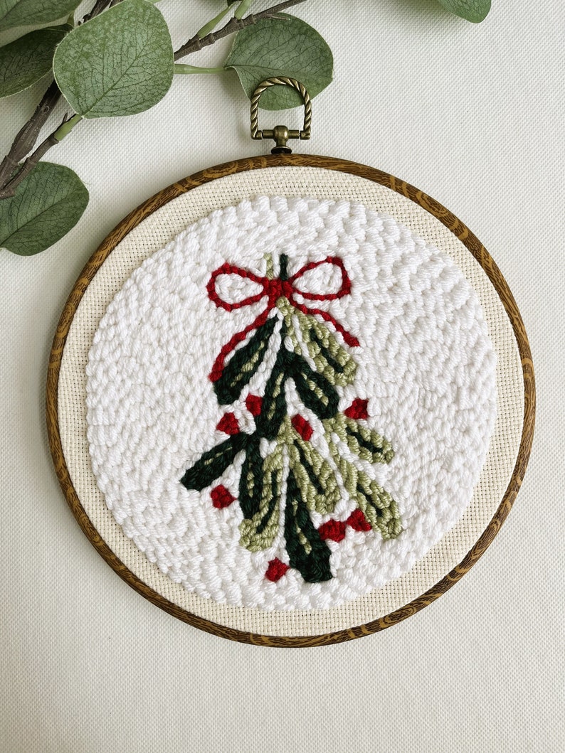 Finished Mistletoe Punch Needle Décor for Christmas Holiday. Shown in faux wood display hoop.