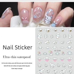 Op de afbeelding: Een vel witte nagelstickers met een lichtblauw en roze cartoon-hondendesign. De stickers zijn gerangschikt in rijen en kolommen. De tekst "JO-2230" is op het vel gedrukt.