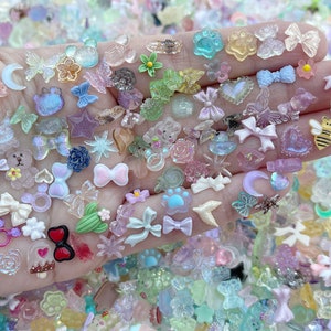 May include: A collection of colorful resin charms in various shapes, including butterflies, stars, hearts, bows, and animals. The charms are perfect for adding a touch of whimsy to jewelry, crafts, and other projects.