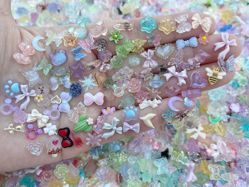 May include: A collection of colorful resin charms in various shapes, including butterflies, stars, hearts, bows, and animals. The charms are perfect for adding a touch of whimsy to jewelry, crafts, and other projects.