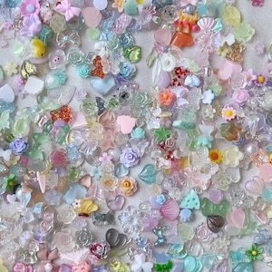 May include: A large assortment of colorful, glittery, and translucent resin charms in various shapes, including hearts, stars, butterflies, flowers, and more. These charms are perfect for adding a touch of whimsy and sparkle to crafts, jewelry, and other projects.