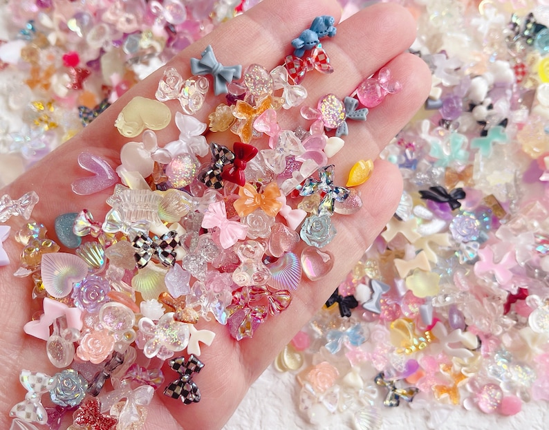 May include: A large assortment of colorful resin embellishments, including bows, hearts, stars, and flowers. The embellishments are perfect for adding a touch of whimsy to crafts, jewelry, and other projects.