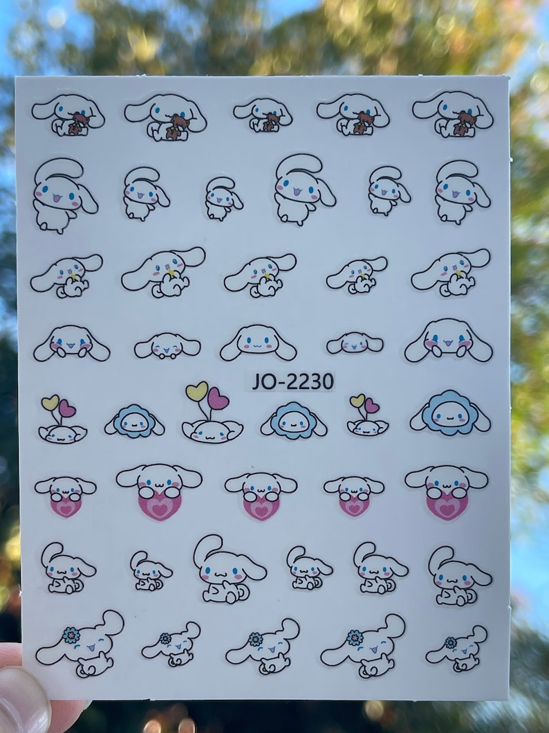 Op de afbeelding: Een vel met witte stickers waarop een cartoonhondje met verschillende gezichtsuitdrukkingen en accessoires te zien is. De hond houdt een teddybeer, een bloem, een hart en een ballon vast. De tekst "JO-2230" staat op het vel gedrukt.