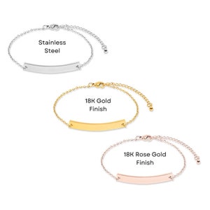 May include: Three delicate chain bracelets with a thin, flat bar charm. The bracelets are shown in three finishes: stainless steel, 18K gold, and 18K rose gold.