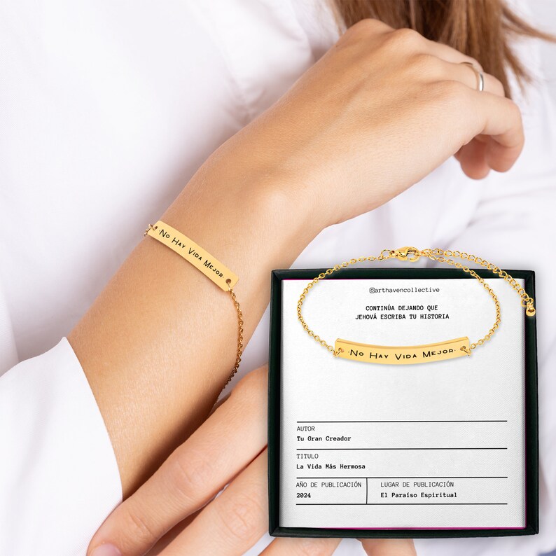 May include: A gold chain bracelet with a rectangular charm that reads "No Hay Vida Mejor". The bracelet is displayed on a white background with a box containing the same bracelet and a card with the text "Continua dejando que Jehova escriba tu historia".
