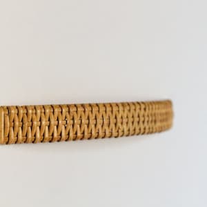 May include: A woven wicker drawer pull in a light brown colour.
