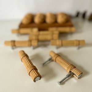 Può includere: Set di sei pomelli per armadi in rattan intrecciato naturale con viti argentate. I pomelli sono realizzati in rattan intrecciato e hanno una finitura naturale. Le viti sono argentate e sono incluse con i pomelli.