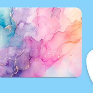 Pode incluir: Mousepad abstrato com um design de aquarela rosa, roxo e azul. O design apresenta redemoinhos e listras de cor com detalhes dourados.