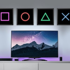 May include: A flat screen television with a snowy mountain range and a starry sky displayed on the screen. Four framed pictures are hanging on the wall above the television. The pictures are black with neon colored shapes inside. The shapes are a square, a circle, a triangle, and an X.