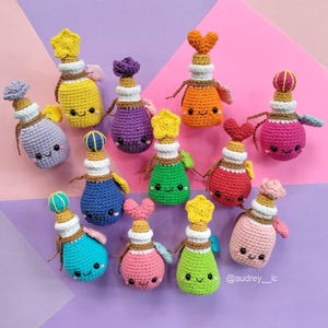 Puede incluir: Una colección de botellas de pociones de ganchillo coloridas con caras sonrientes. Cada botella tiene un adorno único, que incluye estrellas, corazones y flores. Las botellas son de varios colores como amarillo, morado y rosa, con detalles de hilo marrón.