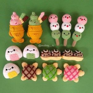 Może przedstawiać: Kolekcja pluszaków amigurumi wykonanych na szydełku, w tym zielony i biały rożek lodowy, różowy i biały rożek lodowy, trzy zielone i różowe kulki mochi na patyku, dwa onigiri, trzy takoyaki i trzy żółwie. Pluszaki są wykonane ręcznie i mają urocze buźki.