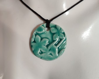 Collier avec pendentif rond en céramique de couleur turquoise à décor floral