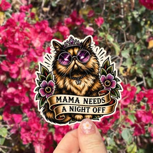 May include: A die-cut sticker featuring a fluffy brown cat wearing a purple-jeweled crown, round purple-tinted sunglasses, and a collar with a butterfly charm. The cat is framed by purple flowers and green leaves, with a banner reading MAMA NEEDS A NIGHT OFF.