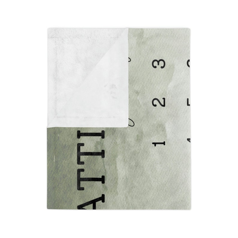 Pu&ograve; includere: Una morbida coperta bianca e verde con la scritta "ATTI" stampata in nero. La coperta ha un design simile all'acquerello con i numeri 1, 2 e 3. La coperta &egrave; piegata, rivelando un interno bianco.