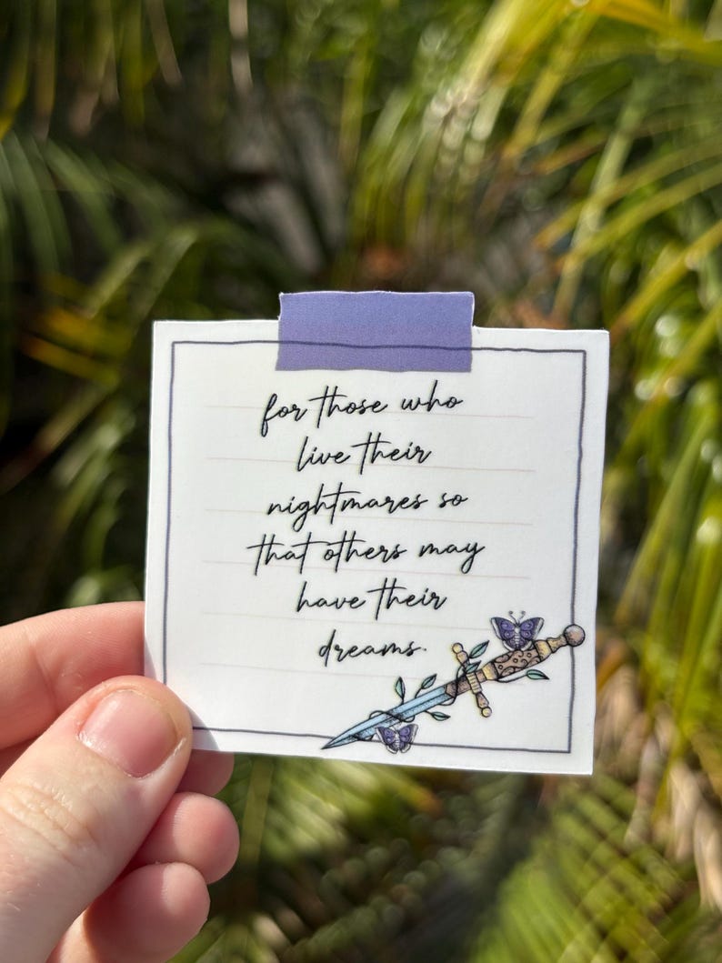 May include: A white sticker with a purple tape strip at the top. The sticker has a handwritten quote: "for those who live their nightmares so that others may have their dreams." A decorative sword and butterfly graphic is on the bottom right.
