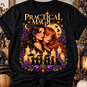 以下が含まれることがあります： 「PRACTICAL MAGIC」という文字がプリントされた黒いTシャツ。長い髪の女性2人が描かれ、紫色のラベンダー、光るキャンドル、傘を持つ人々のシルエット、黒猫、満月が周囲を囲むデザイン。