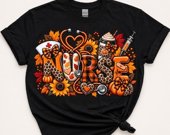 May include: A black t-shirt featuring the word NURSE in large, patterned letters. The design includes orange and brown autumn leaves, sunflowers, pumpkins, a stethoscope shaped like a heart, a coffee cup, a syringe, and a nurse cap with a red cross.
