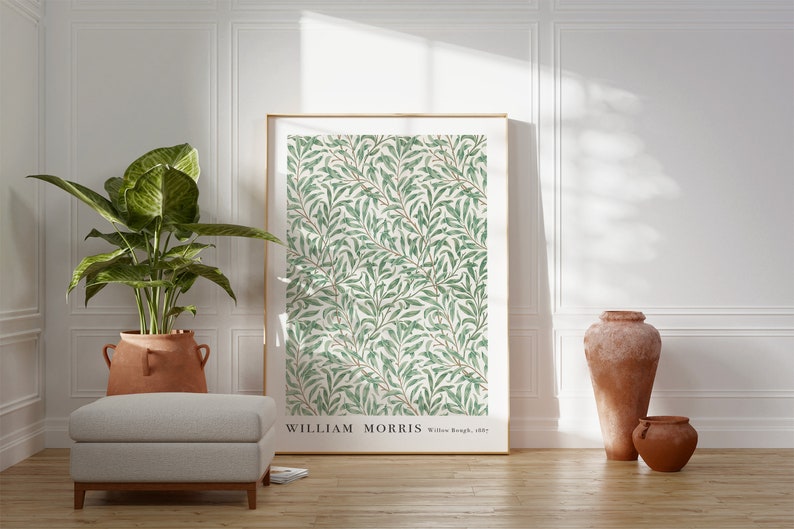 Puede incluir: Una impresi&oacute;n enmarcada de un patr&oacute;n floral verde y blanco con el texto "WILLIAM MORRIS Willow Bough, 1887". La impresi&oacute;n est&aacute; colgada en una pared blanca en una habitaci&oacute;n con una planta en maceta y dos jarrones de terracota.