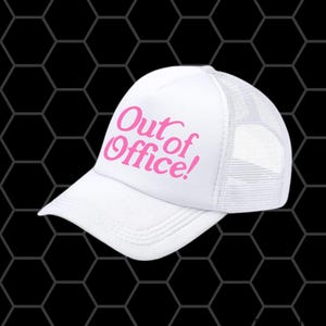 Op de afbeelding: Witte truckerpet met een gebogen klep en mesh achterkant. De pet heeft de tekst "Out of Office!" in roze letters op de voorkant. De pet staat tegen een zwarte achtergrond met een honingraatpatroon.