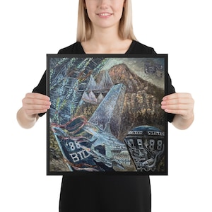 Op de afbeelding: Een ingelijst schilderij van een blauw en grijs vliegtuig met de tekst "86 BTD" en "UNITED STATES 1988" aan de zijkant. Het schilderij is geschilderd tegen de achtergrond van een bergketen en een skyline van een stad.
