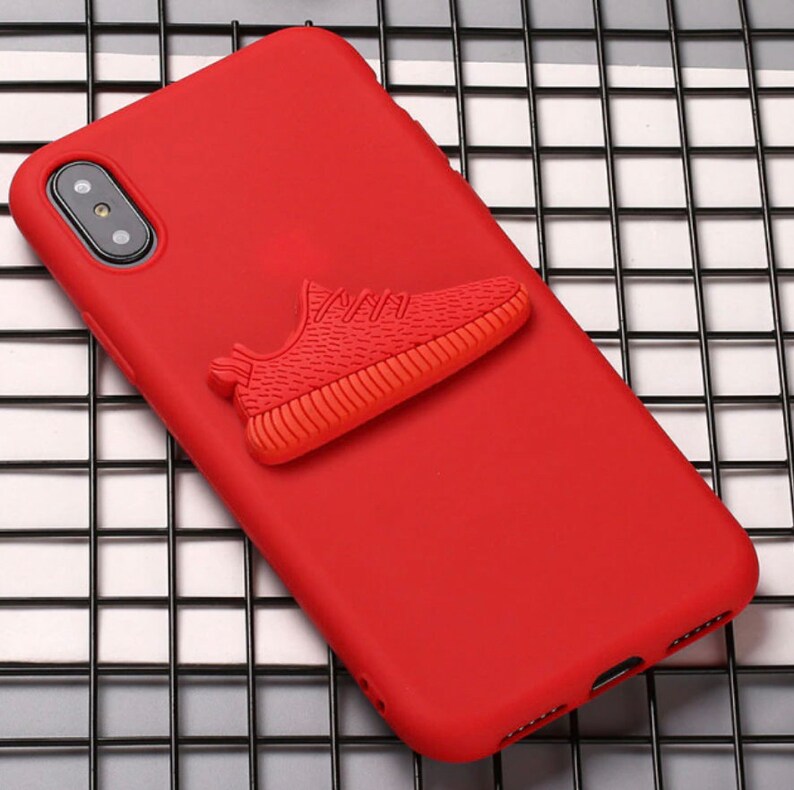 Puede incluir: Funda de tel&eacute;fono roja con una zapatilla roja 3D unida a la parte posterior.