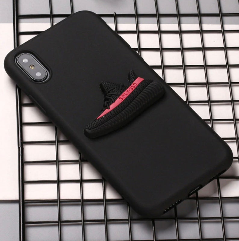 Puede incluir: Funda de tel&eacute;fono negra con un dise&ntilde;o de zapatilla 3D roja y negra. La zapatilla tiene el texto "SPLY-350" en el lateral.
