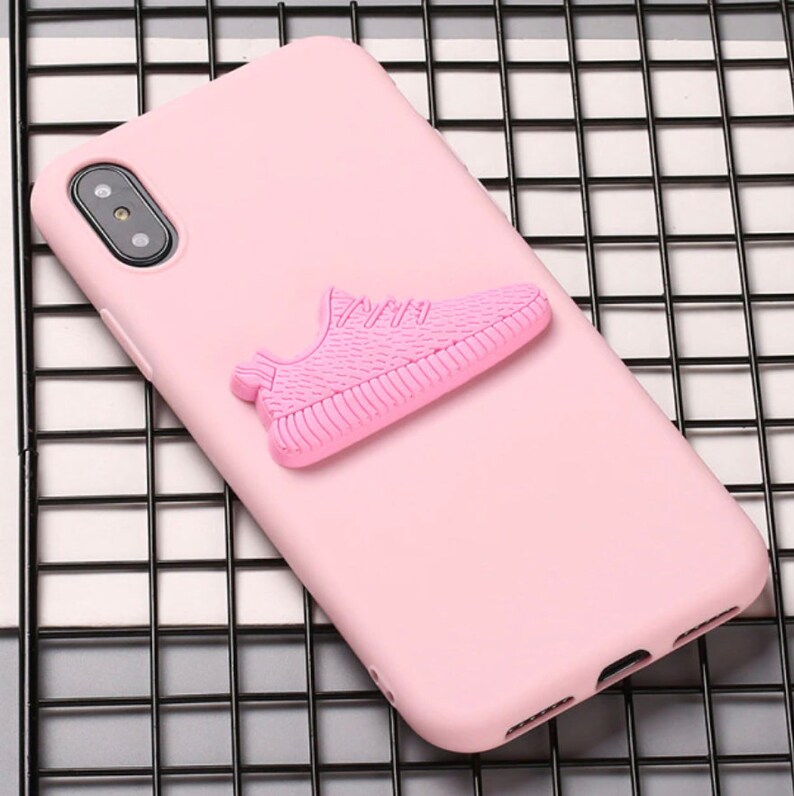 Puede incluir: Una funda de tel&eacute;fono rosa con un dise&ntilde;o de zapatilla rosa en 3D. La funda est&aacute; hecha de un material suave y flexible.