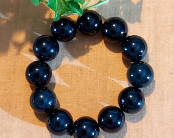 May include: A black beaded bracelet with round, shiny beads.