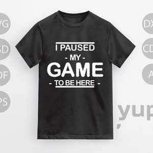 May include: Black t-shirt with white text that reads "I paused my game to be here".
