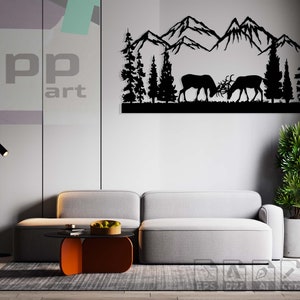 Puede incluir: Arte de pared de metal negro que representa una cordillera con dos ciervos en silueta en primer plano. El arte está colgado en una pared gris sobre un sofá gris y una mesa de café.