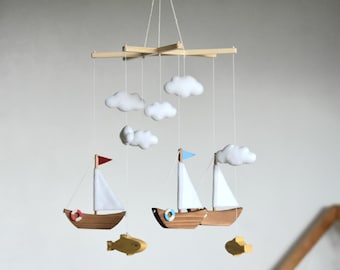 Handgemaakte oceaankwekerijmobiel: houten zeilboten en vilten wolken