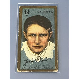 K&ouml;nnte beinhalten: Eine Vintage-Baseballkarte mit einem Portr&auml;t von Josh Devore, einem Spieler der New York Giants. Die Karte hat einen blauen Hintergrund mit dem Teamlogo und dem Wort "Giants" in Gold gedruckt. Devore's Unterschrift ist unter seinem Portr&auml;t gedruckt, zusammen mit dem Text "Of the New York Nationals".