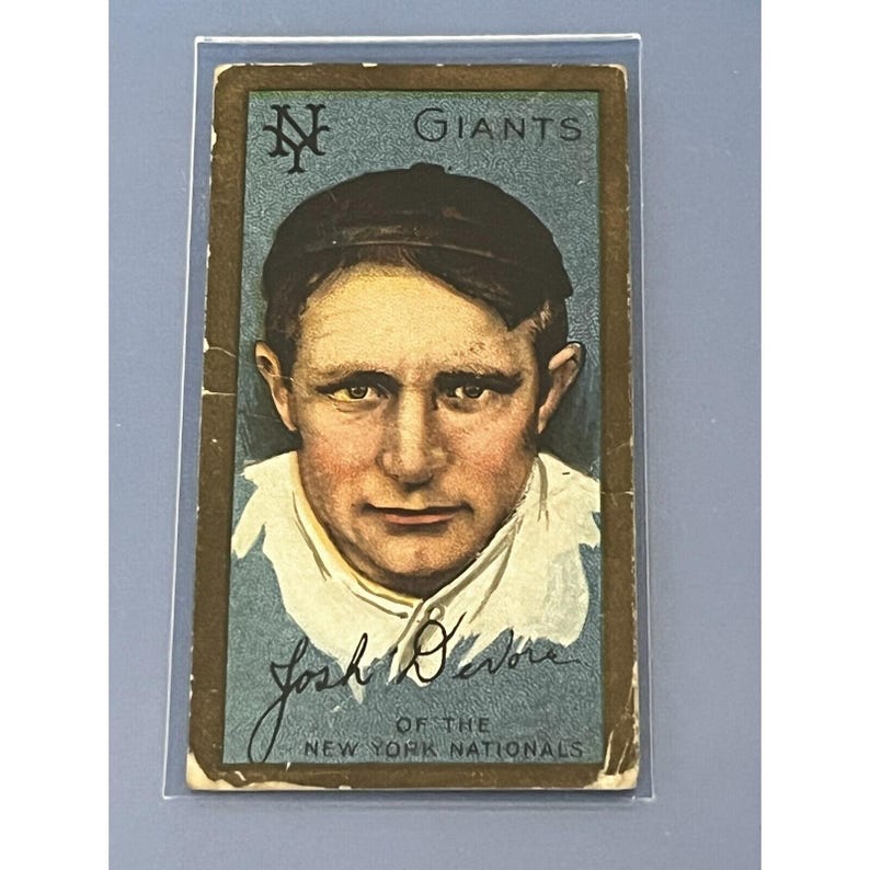 K&ouml;nnte beinhalten: Eine Vintage-Baseballkarte mit einem Portr&auml;t von Josh Devore, einem Spieler der New York Giants. Die Karte hat einen blauen Hintergrund mit dem Teamlogo und dem Wort "Giants" in Gold gedruckt. Devore's Unterschrift ist unter seinem Portr&auml;t gedruckt, zusammen mit dem Text "Of the New York Nationals".