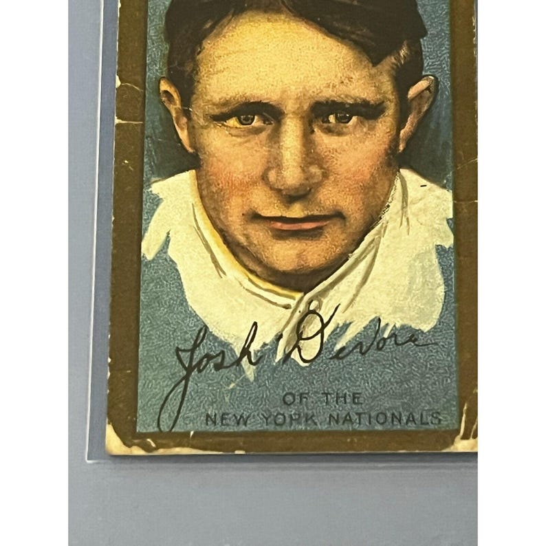 K&ouml;nnte beinhalten: Eine Vintage-Baseballkarte mit einem Portr&auml;t von Josh Devore von den New York Nationals. Die Karte hat einen goldenen Rand und einen blauen Hintergrund.