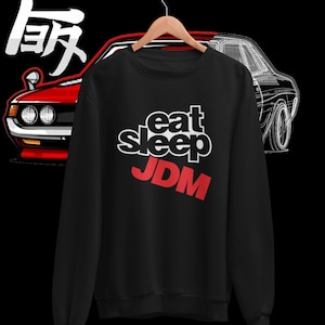 May include: Black sweatshirt with a white graphic that says "eat sleep JDM" in a bold font. The word "JDM" is in red.