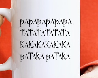 Op de afbeelding: Een witte keramische mok met zwarte tekst. De mok wordt vastgehouden door een persoon die een oranje trui draagt. De tekst op de mok is in een gestileerd lettertype en lijkt een reeks herhalende tekens te zijn.