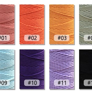 K&ouml;nnte beinhalten: Zw&ouml;lf Spulen mit Baumwollschnur in verschiedenen Farben, darunter Rosa, Orange, Gelb, Gr&uuml;n, Blau, Lila, Lavendel und Schwarz. Jede Spule ist mit einer Nummer von 01 bis 12 gekennzeichnet.