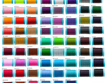 Peut inclure: Une collection de 100 bobines de fil de différentes couleurs, chaque bobine est numérotée. Les bobines sont disposées en rangées et en colonnes sur un fond blanc.