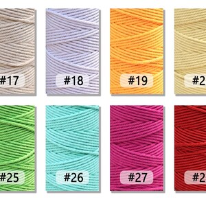 K&ouml;nnte beinhalten: Acht Spulen mit Baumwollschnur in verschiedenen Farben, darunter Beige, Wei&szlig;, Gelb, Creme, Gr&uuml;n, Hellblau, Rosa und Rot. Jede Spule ist mit einer Nummer gekennzeichnet.