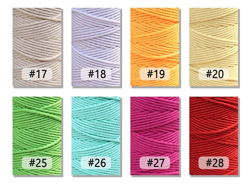 K&ouml;nnte beinhalten: Acht Spulen mit Baumwollschnur in verschiedenen Farben, darunter Beige, Wei&szlig;, Gelb, Creme, Gr&uuml;n, Hellblau, Rosa und Rot. Jede Spule ist mit einer Nummer gekennzeichnet.