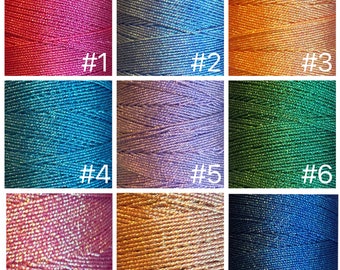 May include: Nine spools of metallic embroidery thread in various colors, including pink, blue, orange, green, and purple. Each spool is labeled with a number from 1 to 9.