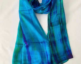 May include: A blue silk scarf with green and purple abstract stripes.
