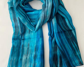 May include: A blue and black striped silk scarf with a flowing design.
