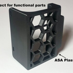 Op de afbeelding: Een zwart kunststof onderdeel met een honingraatpatroon. De tekst "ASA Plastic" staat onder het onderdeel.